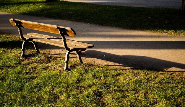 Empty wooden bench in a park during daytime