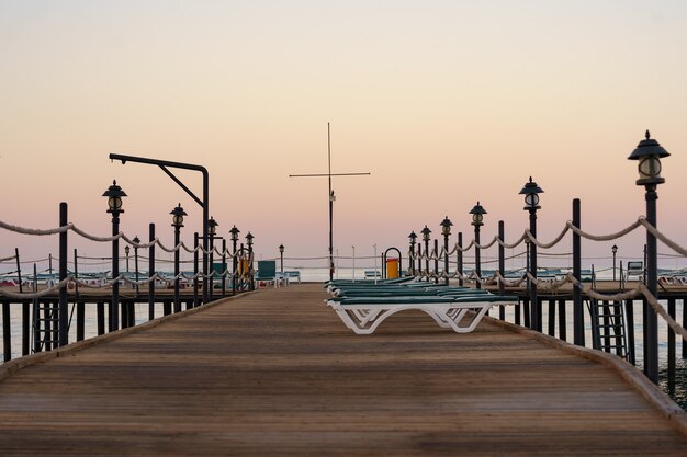 Empty wooden pier at beautiful calm morning. Tourist wharf in bay of sea