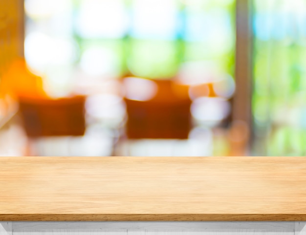 Пустой деревянный стол с размытым кафе bokeh свет как фон Premium Фотографии