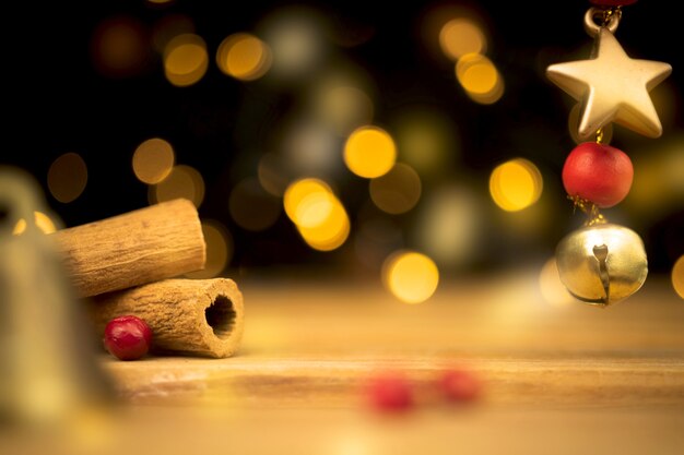 Empty wooden table with blurred christmas lights at background. wooden table with new year decoration, cinnamons and golden star close-up