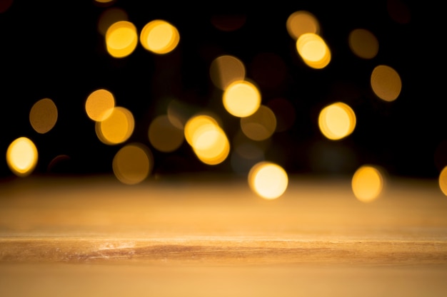 Empty wooden table with blurred christmas lights at dark background. free space for montage, mockup for product designs