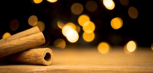 Empty wooden table with christmas lights and cinnamons. happy new year and holiday concept. blank space for montage product placement display photo