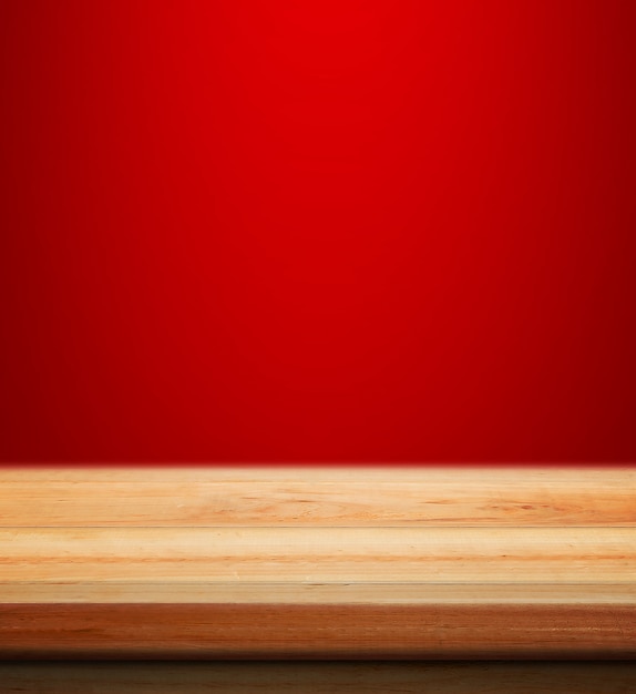 ぼんやりと製品の配置のための赤いクリスマスの背景と空の木製のテーブルクリスマスの壁紙の背景