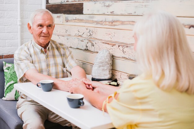 Enamored senior couple sitting in cafe