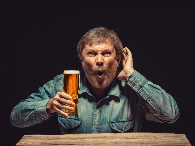 The enchanted and emotional fan with glass of beer