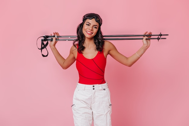 Free photo enchanting brunette woman holding ski poles