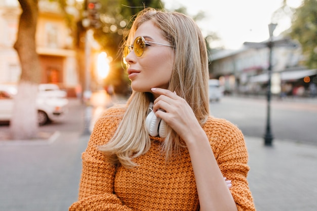 Enchanting fair-haired european woman looking around, trying to find friend