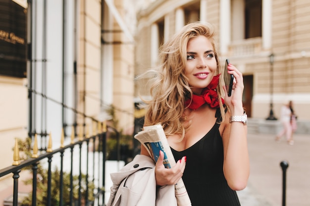 Enchanting tanned female model looking away with inspired smile hanging out outside