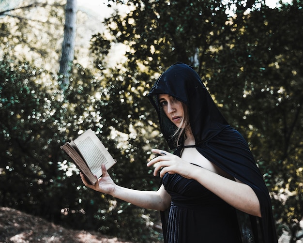 Чародейка с книгой заклинаний в солнечном лесу
