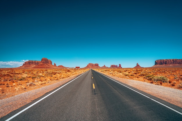 Endless road through the Monument Valley National park with amazing rock formations