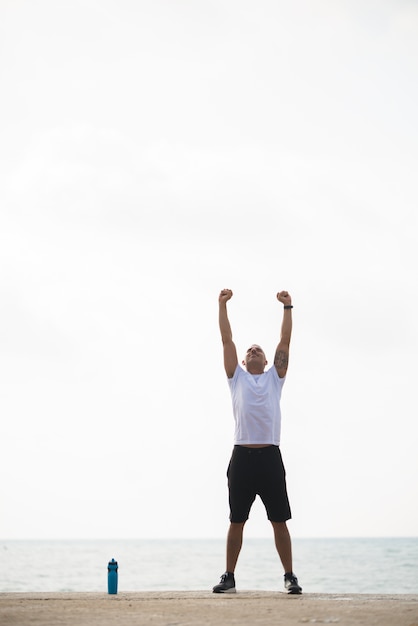 Free photo energetic man doing morning exercise on beach