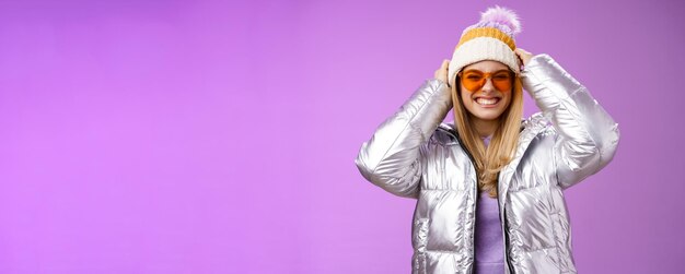 Энергичная смелая нахальная молодая привлекательная женщина весело проводит зимнюю поездку с друзьями, учится кататься на сноуборде улыбается