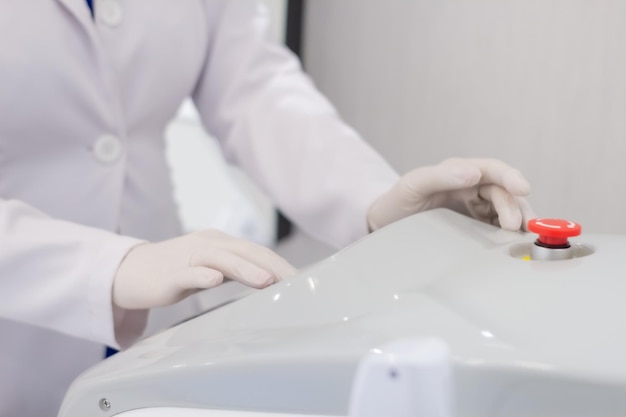 Enfermera con guantes medicos manpula la maquina de tratamientos Premium Фотографии