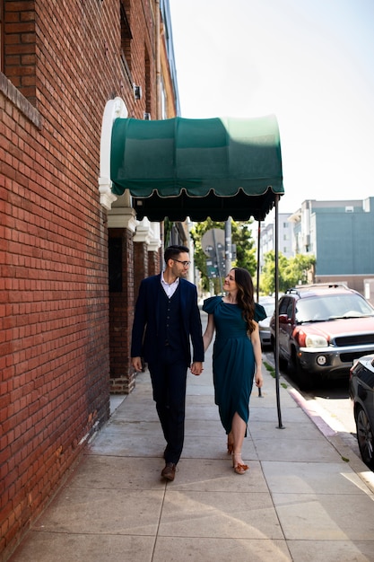 Free photo engaged couple posing together in the city