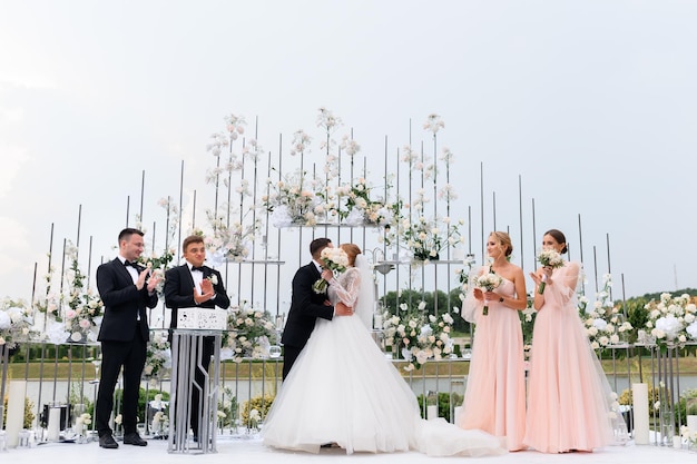 Foto gratuita fidanzamento della sposa con lo sposo sulla cerimonia all'aperto con gli amici