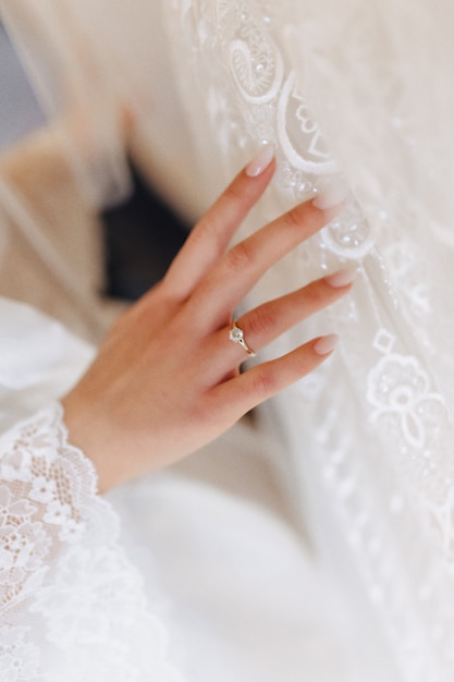 Обручальное кольцо с камнем на нежной руке невесты