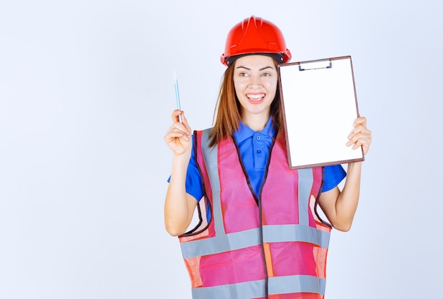 Engineer girl in uniform holding a blank reporting file. 