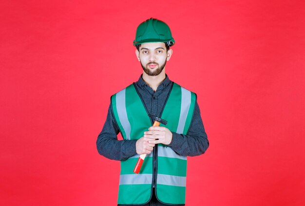 Engineer in green uniform and helmet holding a wooden ax. 