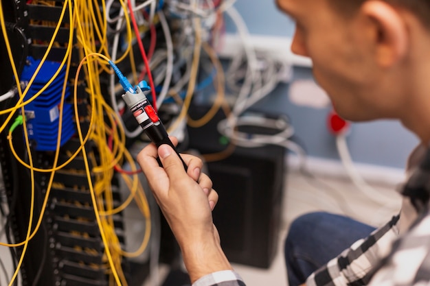 Foto gratuita uomo dell'ingegnere che collauda la fibra ottica