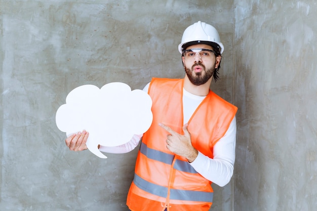 Engineer man in white helmet and protective eyeglasses holding a could shape info board .