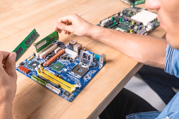 Engineer putting the RAM memory module in motherboard