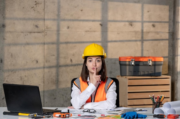 Engineer smart young cute brunette girl civil worker in helmet and vest being quiet