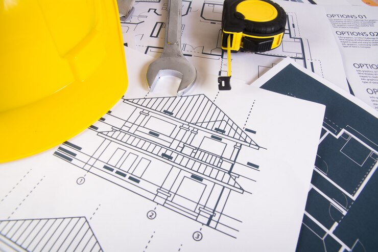 Free Photo engineer workplace with blueprints, protractor and safety helmet.