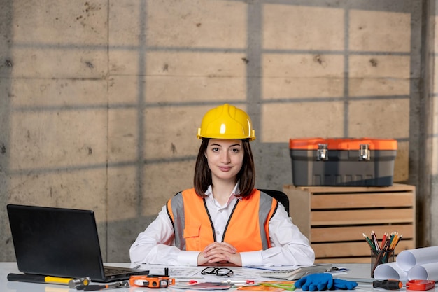 Engineer young cute smart brunette girl civil worker in helmet and vest serious