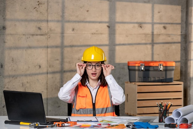 Engineer young cute smart brunette girl civil worker in helmet and vest