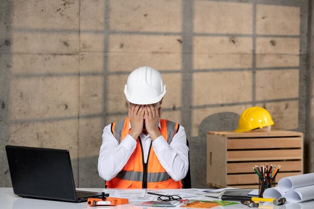 Engineer young handsome smart guy civil worker in helmet and vest tired and sleepy