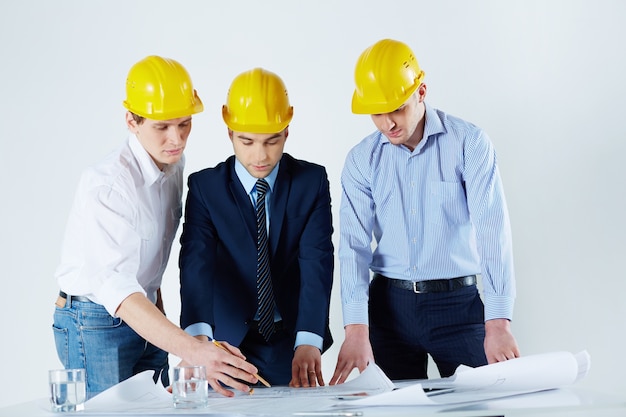 Engineers with helmets reviewing the sketch