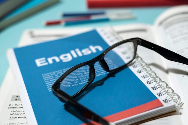 English book with glasses on table