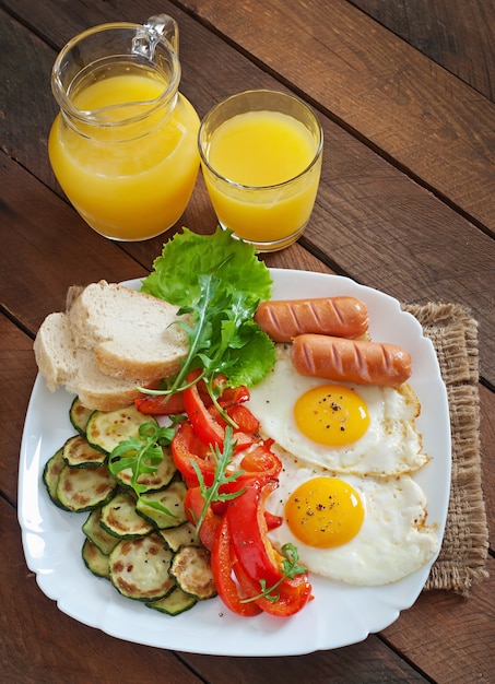 English breakfast - fried eggs, sausages, zucchini and sweet peppers