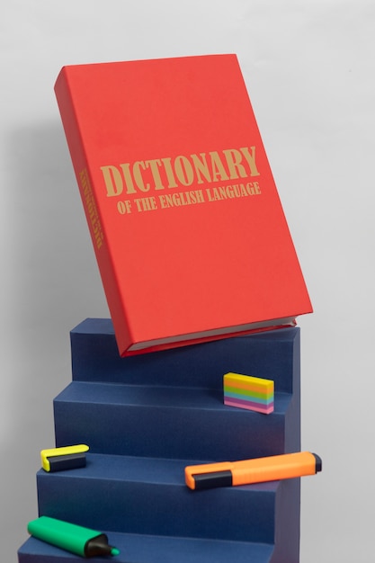 Foto gratuita disposizione dei pennarelli e del dizionario inglese