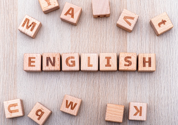 Английское слово деревянным кубиком на деревянном столе, концептуальная картинка об английском языке и образование