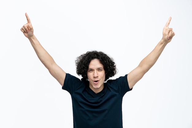 Enjoyed young handsome man looking at camera pointing up with raised hands isolated on white background