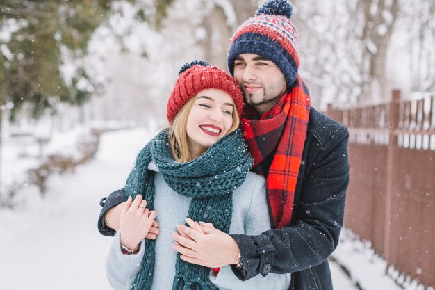 雪の中の美しいカップルを楽しむ