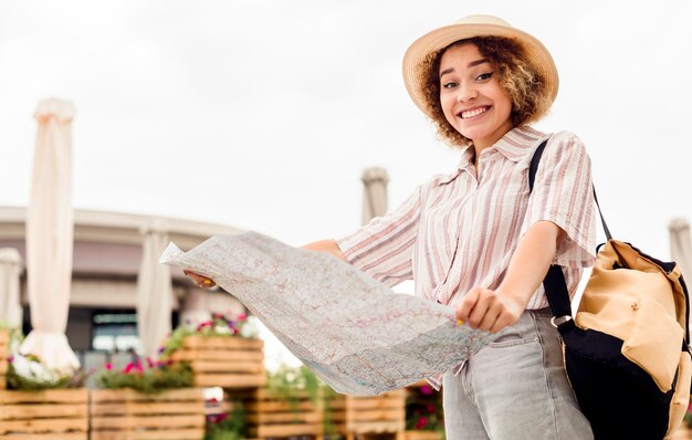 Enthusiast woman traveling alone with a map