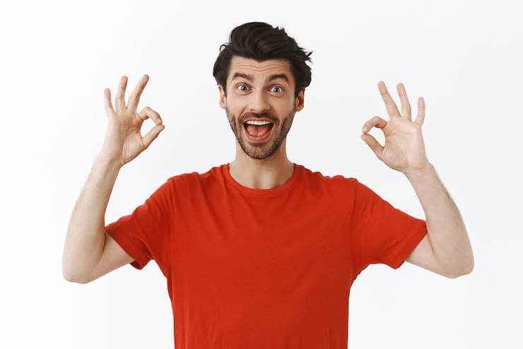 Free Photo enthusiastic goodlooking bearded man in red tshirt showing alright okay or ok sign and smiling pleased give approval recommend awesome product give positive feedback white background