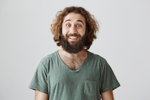 Free photo enthusiastic handsome middle-eastern bearded guy smiling