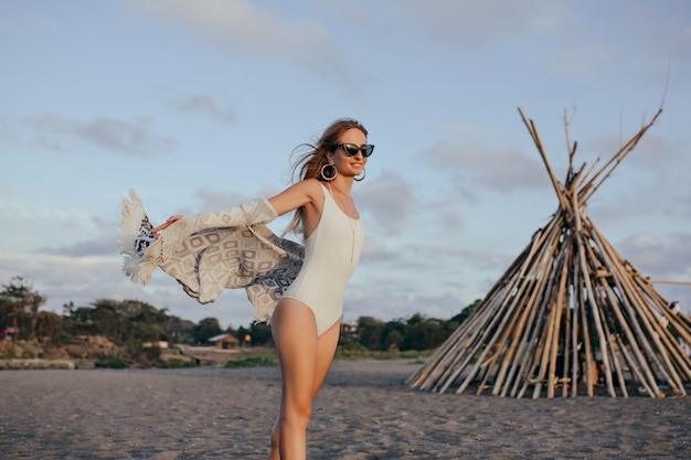 Foto gratuita donna esile entusiasta in occhiali da sole che gode della brezza marina.