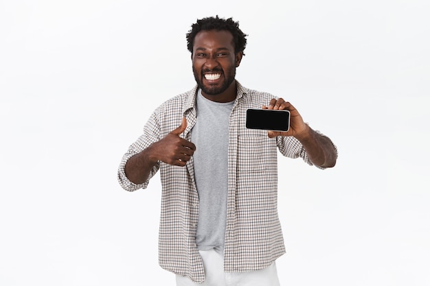 Free photo enthusiastic smiling happy african american guy amazed with awesome new app