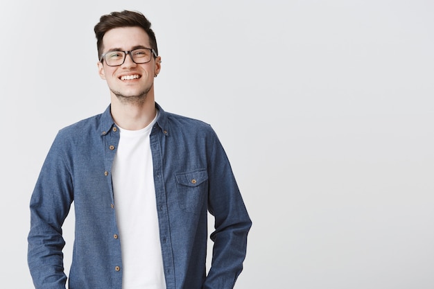 Enthusiastic smiling man looking happy in glasses and casual clothes