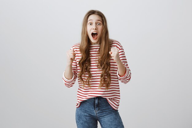 Enthusiastic and surprised girl looking amazed, winning