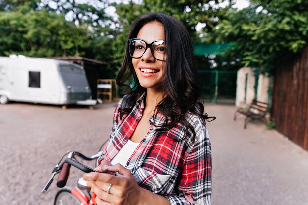 Enthusiastic woman with ring dreamy looking away on nature. Wonderful caucasian girl posing with pleasure on the street in spring morning.