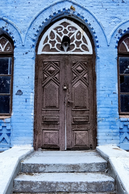 Entrance door in an old abandoned house with lock