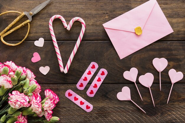 Envelope near bouquet of flowers, scissors and candy canes