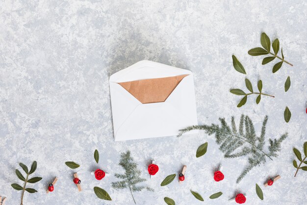 Envelope with green plant branches on table