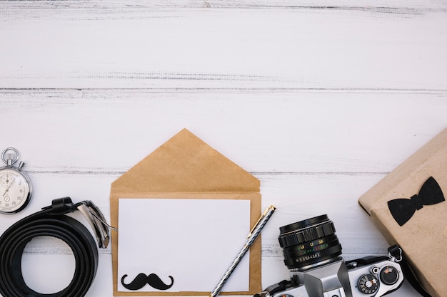 Free photo envelope with paper near camera, box, stop watch and leather strap