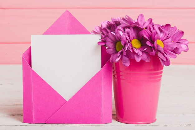 Конверт с куском бумаги и красивые фиолетовые цветы
